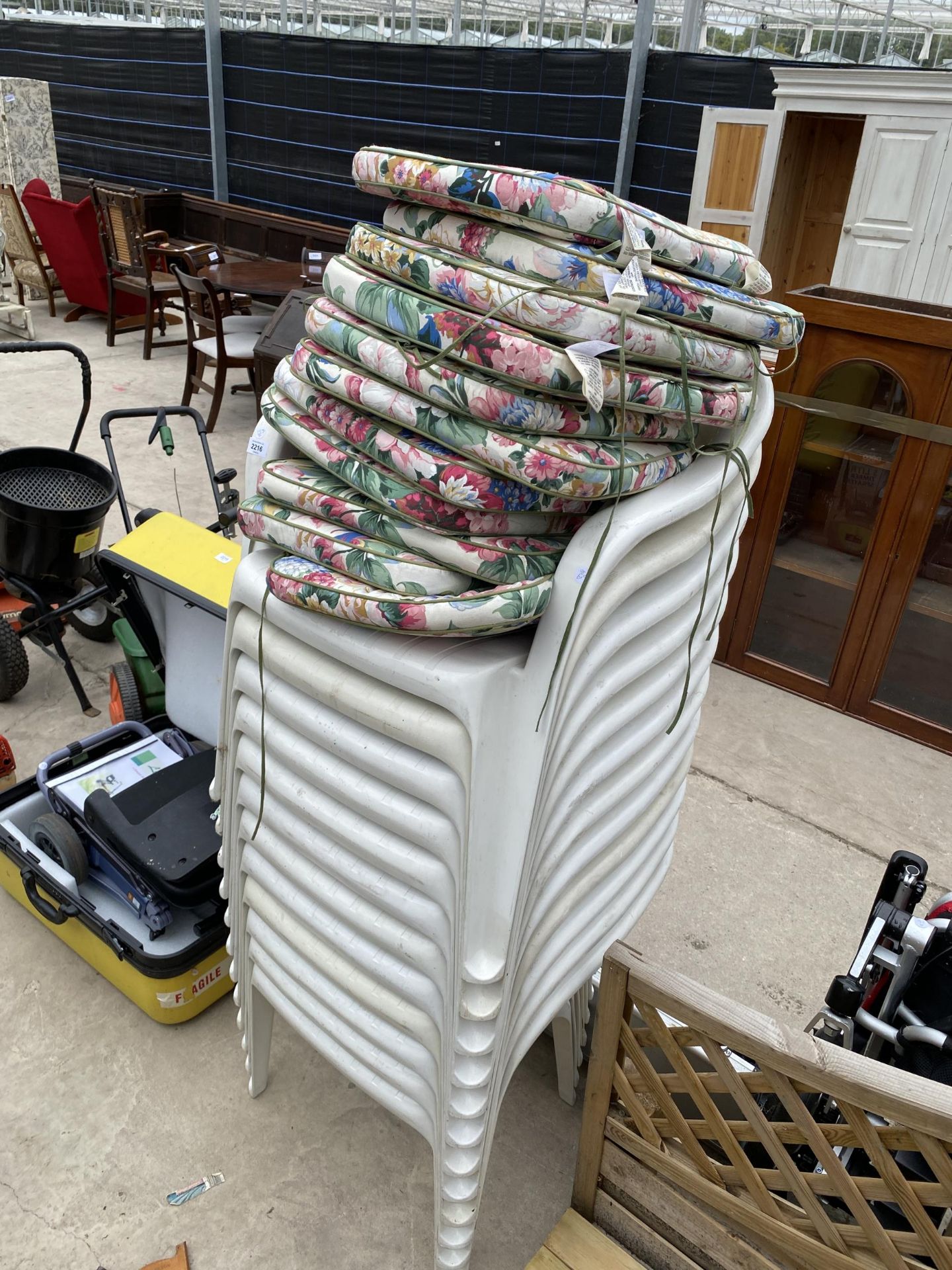 TWELVE WHITE PLASTIC STACKING CHAIRS AND CUSHIONS