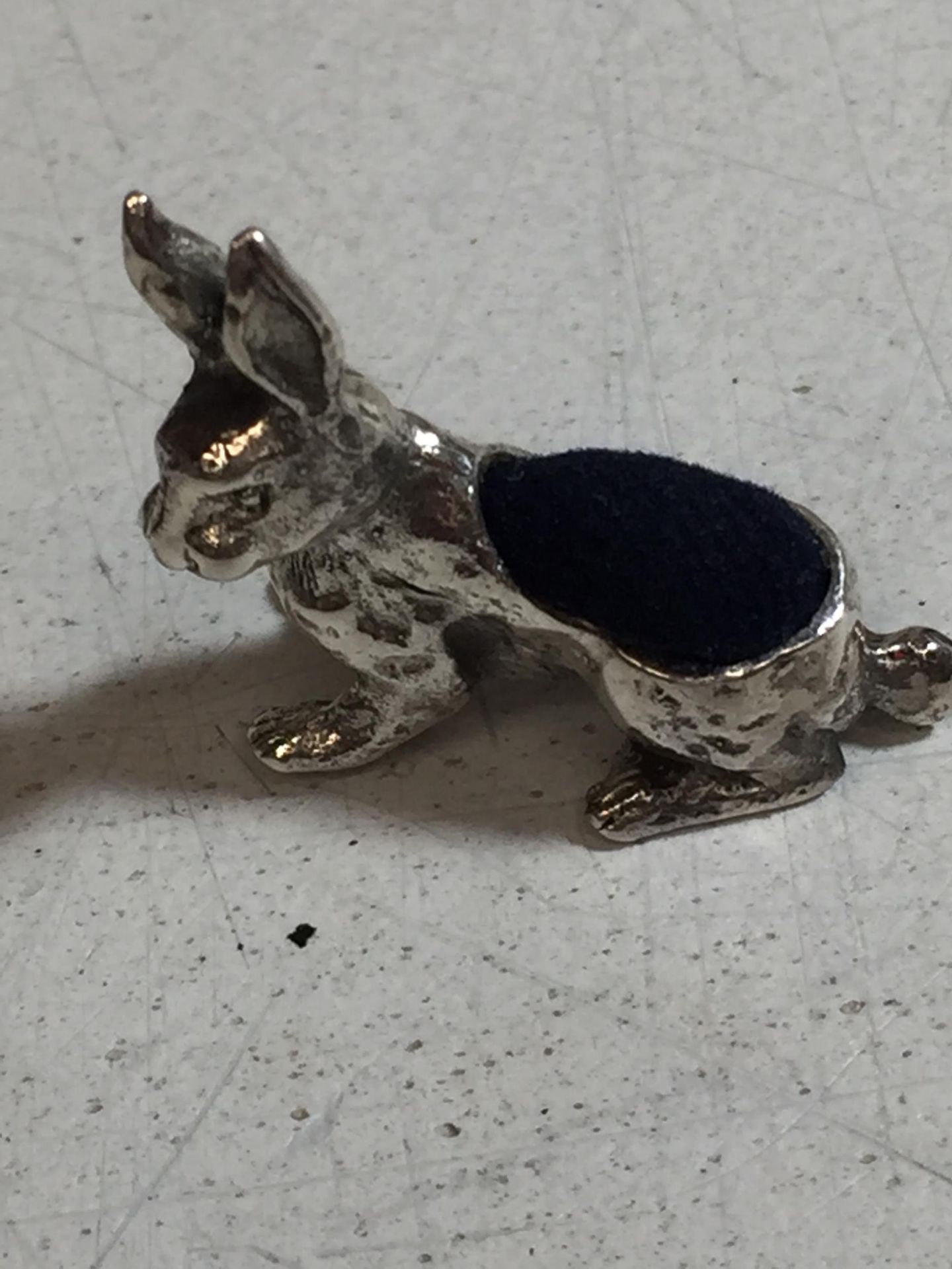 A SILVER PIN CUSHION IN THE SHAPE OF A RABBIT