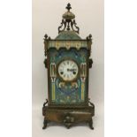 AN ART NOUVEAU CLOISONNE AND BRASS CHIMING MANTLE CLOCK WITH RAM HEAD SIDE DESIGN