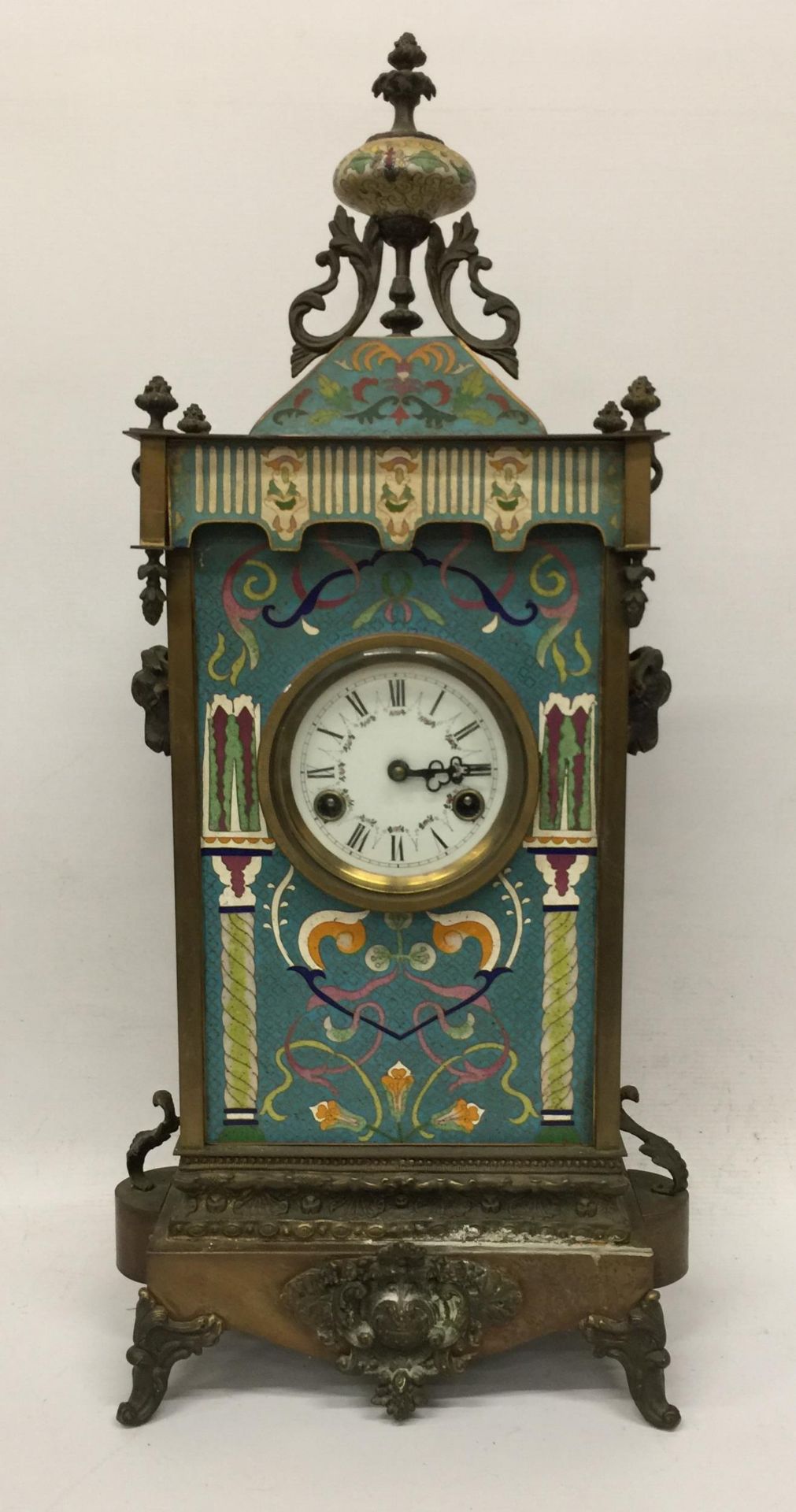 AN ART NOUVEAU CLOISONNE AND BRASS CHIMING MANTLE CLOCK WITH RAM HEAD SIDE DESIGN