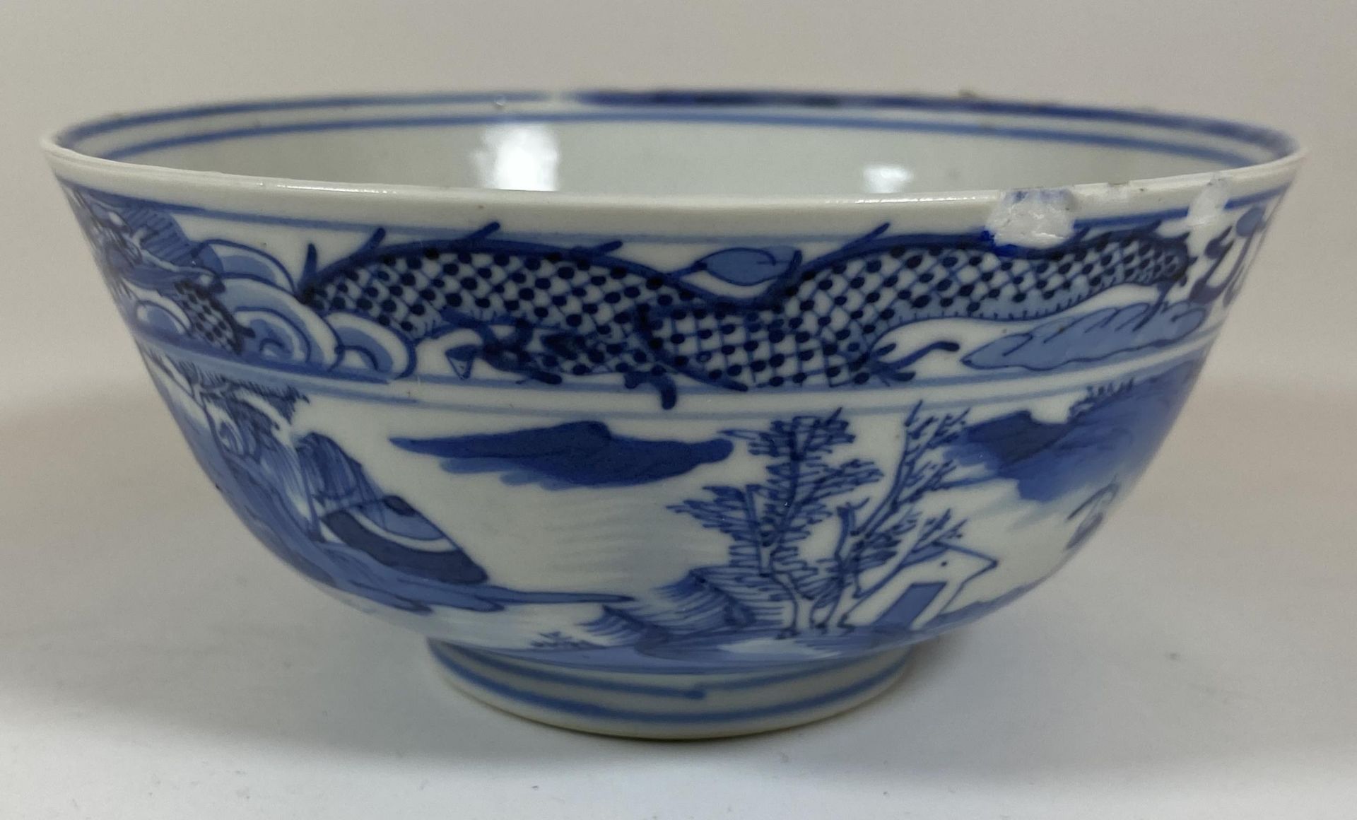 A 19TH CENTURY CHINESE KANGXI STYLE BLUE AND WHITE DRAGON DESIGN BOWL, FOUR CHARACTER MARK TO