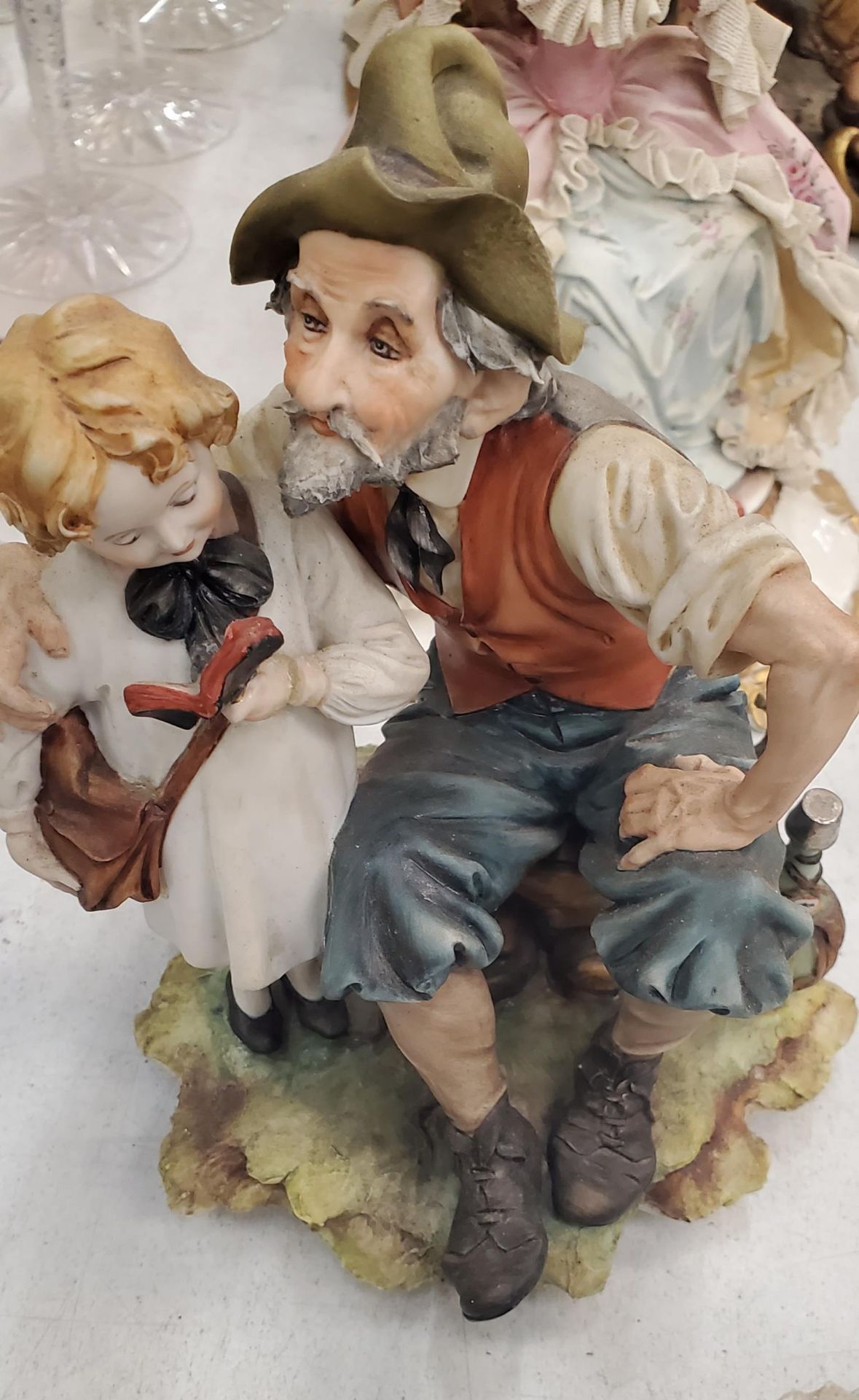 FIVE FIGURES TO INCLUDE THE DRUNKEN TRAMP ON A BENCH, A CAPODIMONTE FIGURE OF A LADY PLAYING A - Image 4 of 5