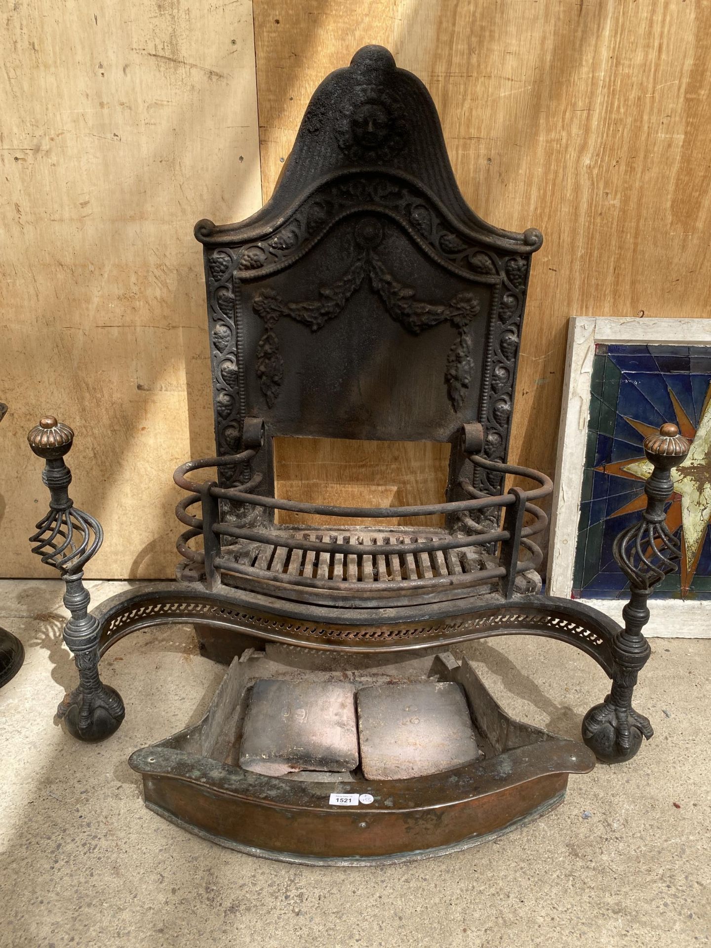 A VINTAGE HEAVY CAST IRON FIREPLACE WITH BALL AND CLAW FOOT FENDER