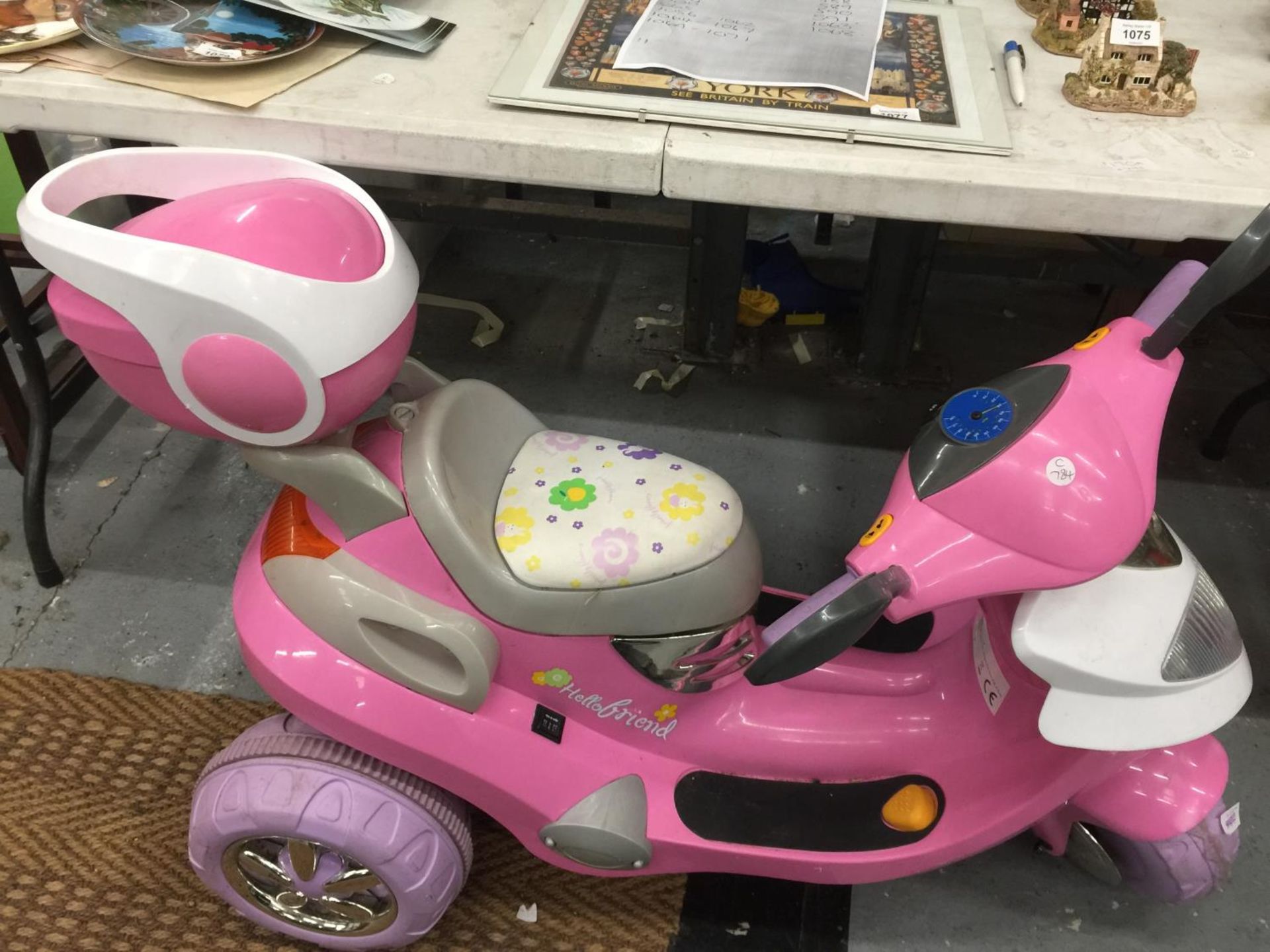 A CHILDREN'S PINK ELECTRIC THREE WHEELED SCOOTER WITH CHARGER - VENDOR STATES IN WORKING ORDER AND