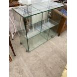 A MODERN GLASS FOUR SECTION DISPLAY STAND ON CASTERS, 35.5X16"