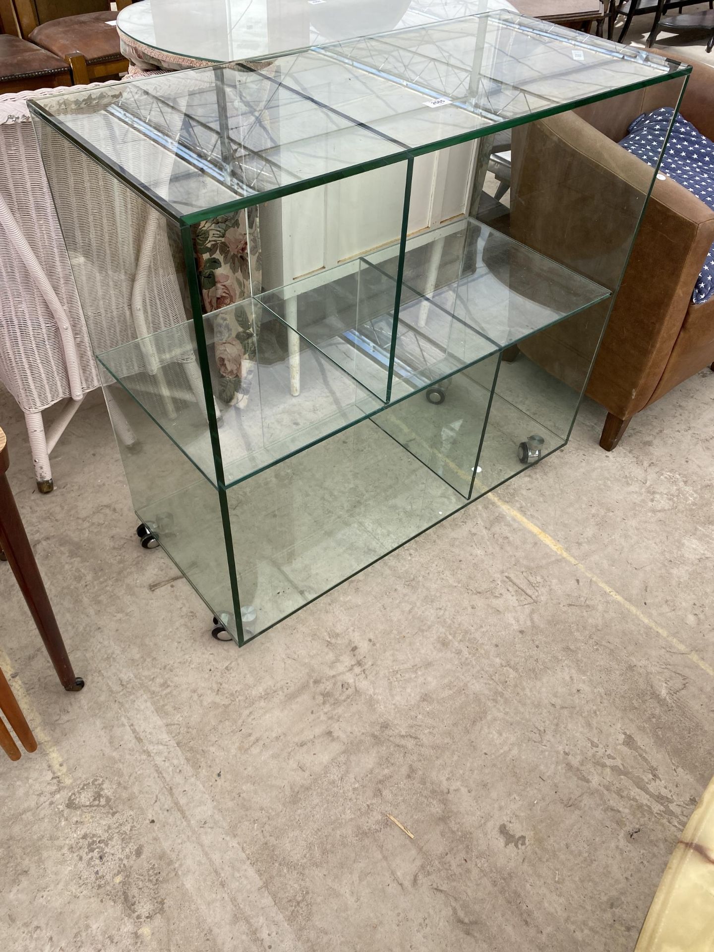 A MODERN GLASS FOUR SECTION DISPLAY STAND ON CASTERS, 35.5X16"