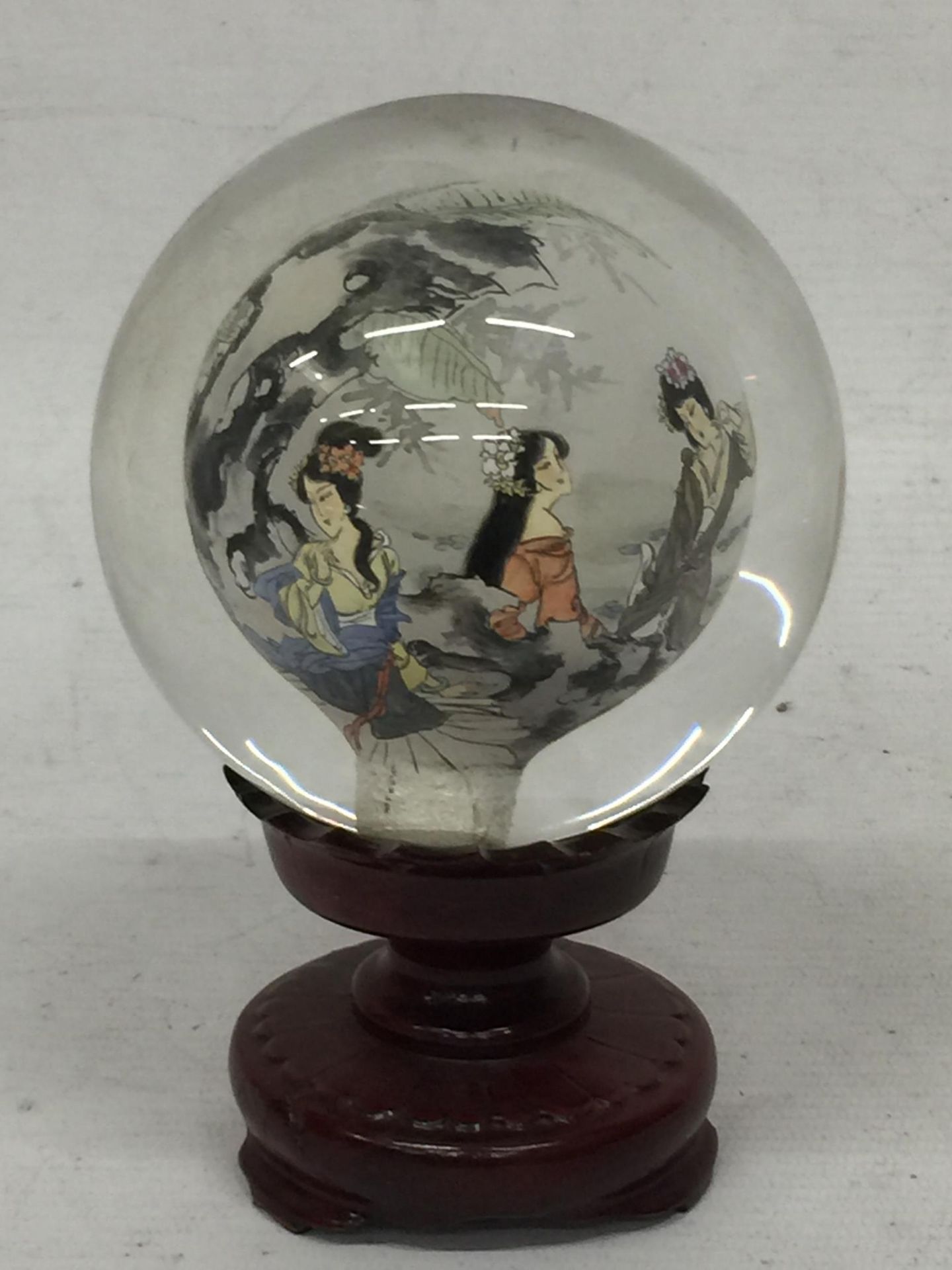 A MODERN ORIENTAL GLASS ORB ON STAND