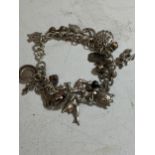 A SILVER CHARM BRACELET WITH 15 CHARMS