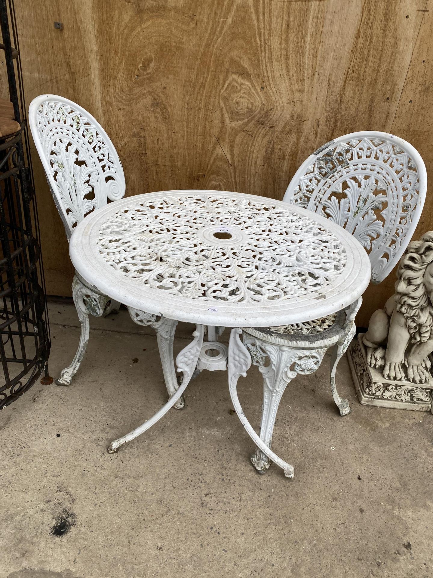 A VINTAGE CAST IRON METAL GARDEN BISTRO TABLE AND TWO CHAIRS
