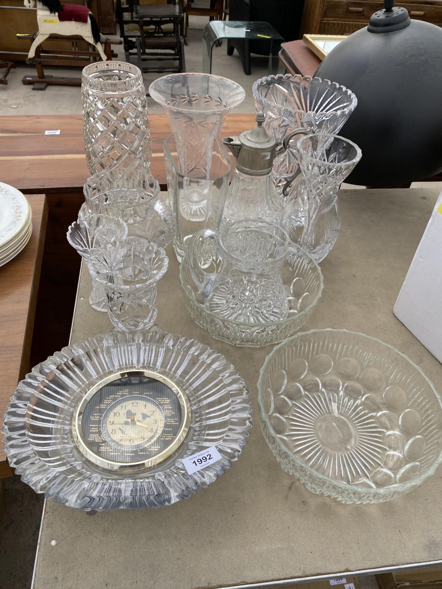 AN ASSORTMENT OF CUT GLASS WARE TO INCLUDE A WORLD CLOCK, A CLARET JUG AND VASES ETC