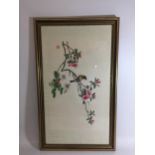 A GILT FRAMED SILK PRINT OF A BIRD AND FLOWER