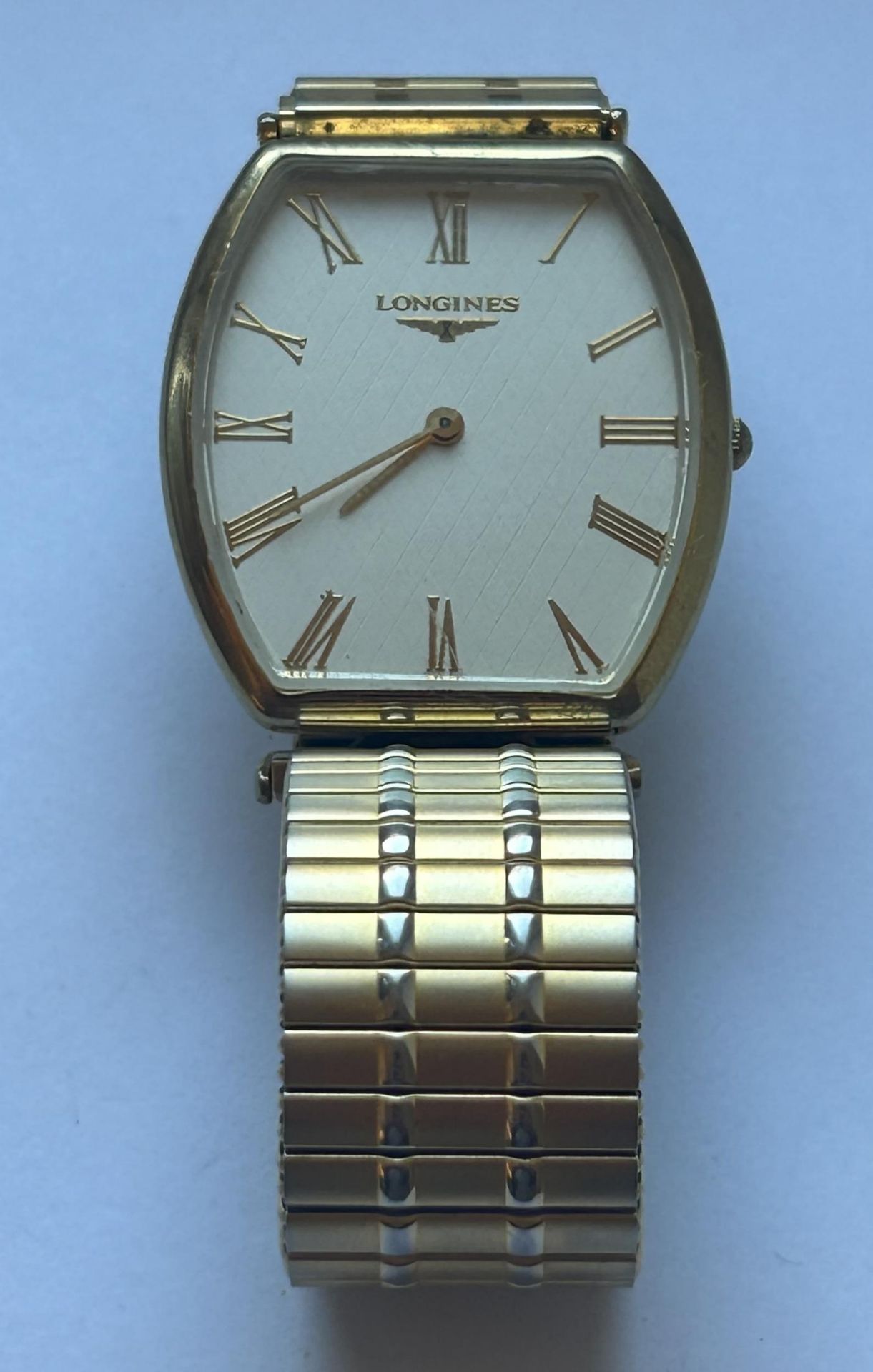 A GENTS LONGINES GOLD PLATED QUARTZ WRIST WATCH ON AN EXPANDING BRACELET (WORKING AT TIME OF