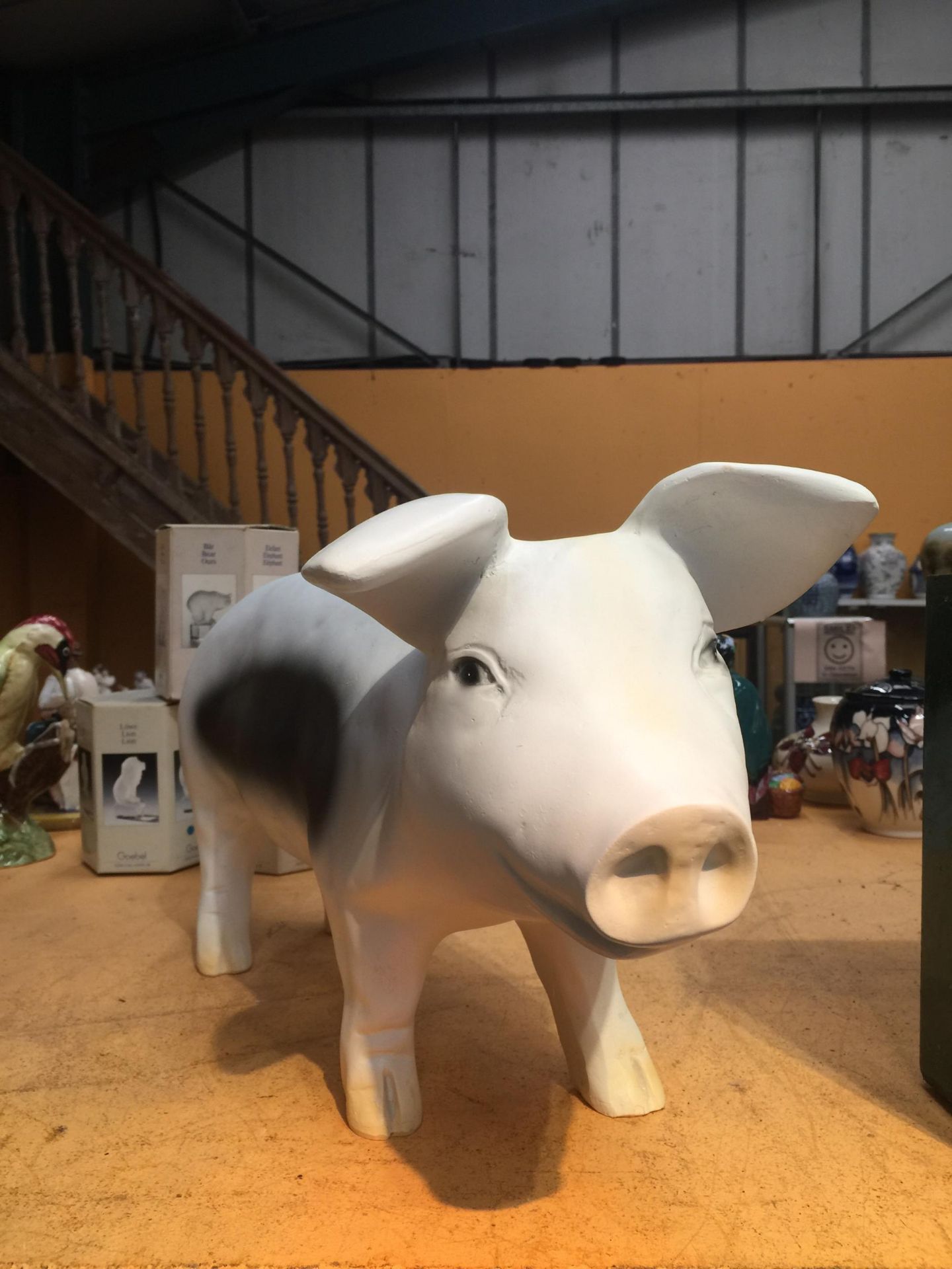 A BLACK AND WHITE GARDEN PIG ORNAMENT