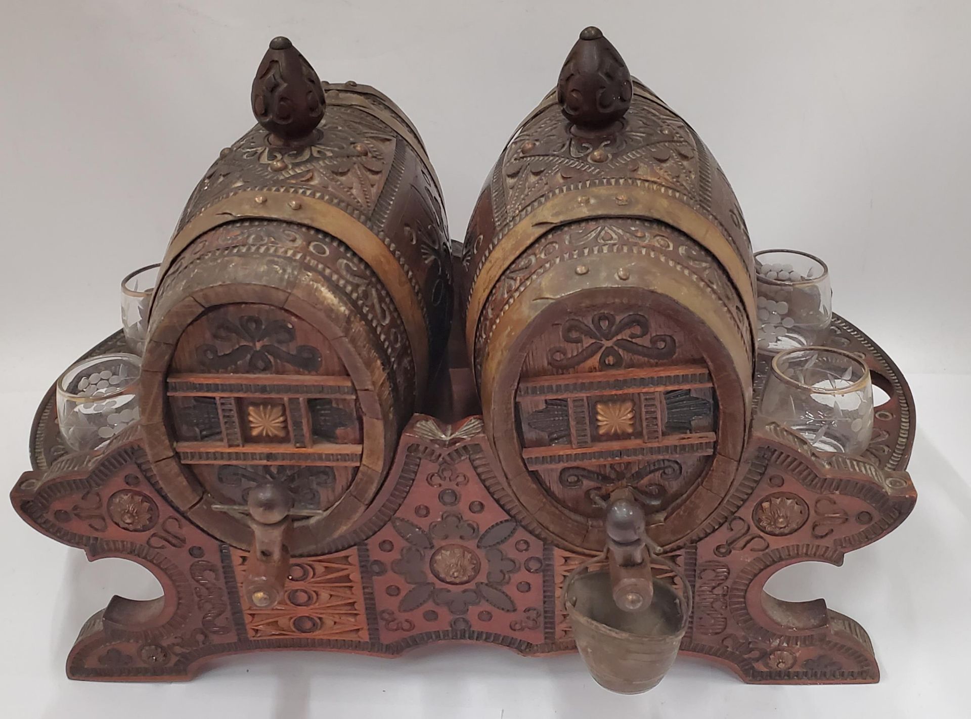 A VINTAGE CARVED WOODEN NORTH AFRICAN DRINKS DISPENSER WITH GLASSES