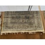 A BEIGE PATTERNED FRINGED RUG