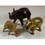 A GROUP OF THREE ELEPHANT FIGURES TO INCLUDE TWO CARVED WOODEN AND A SOLID HEAVY BRASS EXAMPLE,