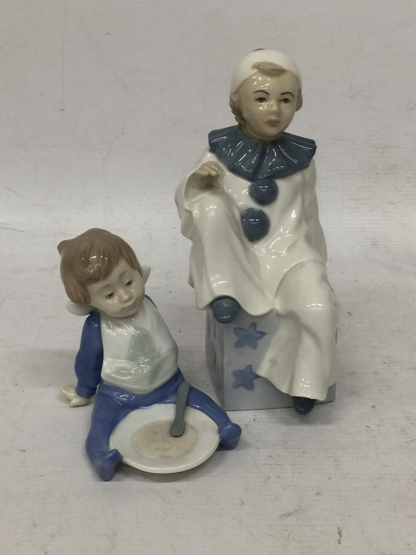 TWO FIGURES - A NAO FIGURE OF A CHILD AND A CASADES CLOWN