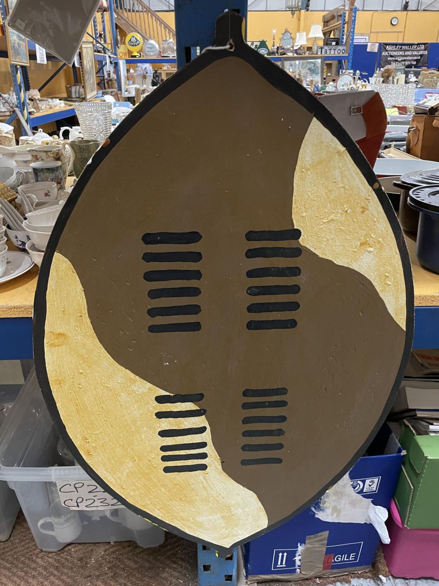 A HAND MADE AND PAINTED AFRICAN STYLE SHIELD IN WOOD, DOUBLE SIDED 97CM X 60CM