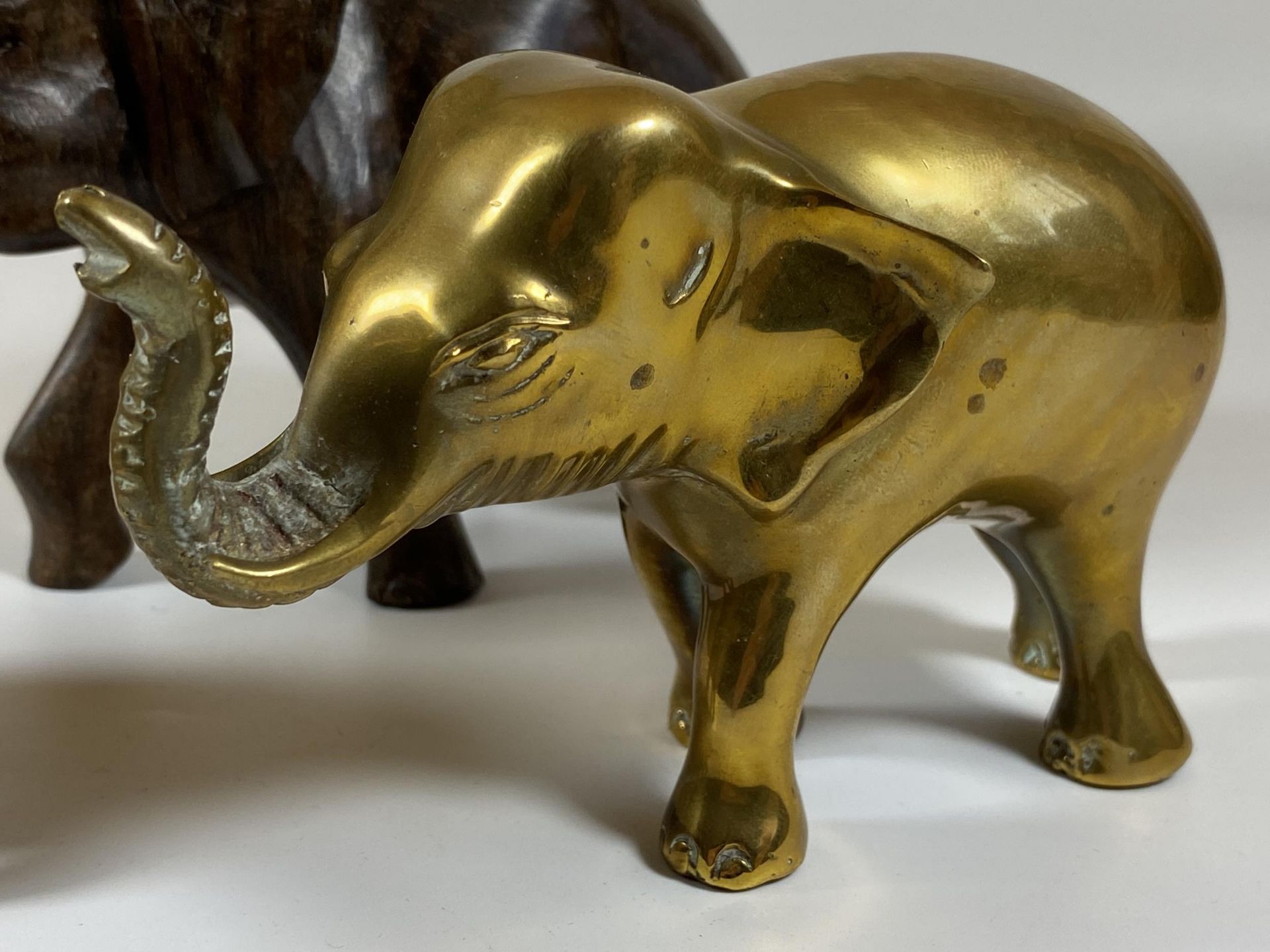 A GROUP OF THREE ELEPHANT FIGURES TO INCLUDE TWO CARVED WOODEN AND A SOLID HEAVY BRASS EXAMPLE, - Image 2 of 5