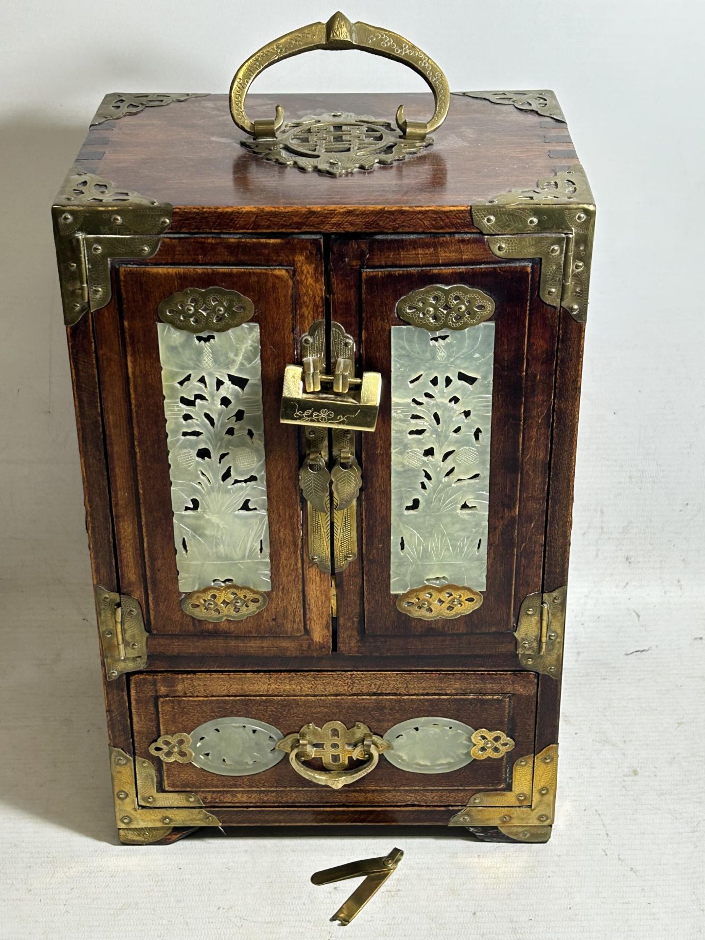 AN ORIENTAL JEWELLERY CABINET, WITH HIDDEN DRAWERS AND BRASS FITTINGS, ALONG WITH JADE STYLE INSERTS