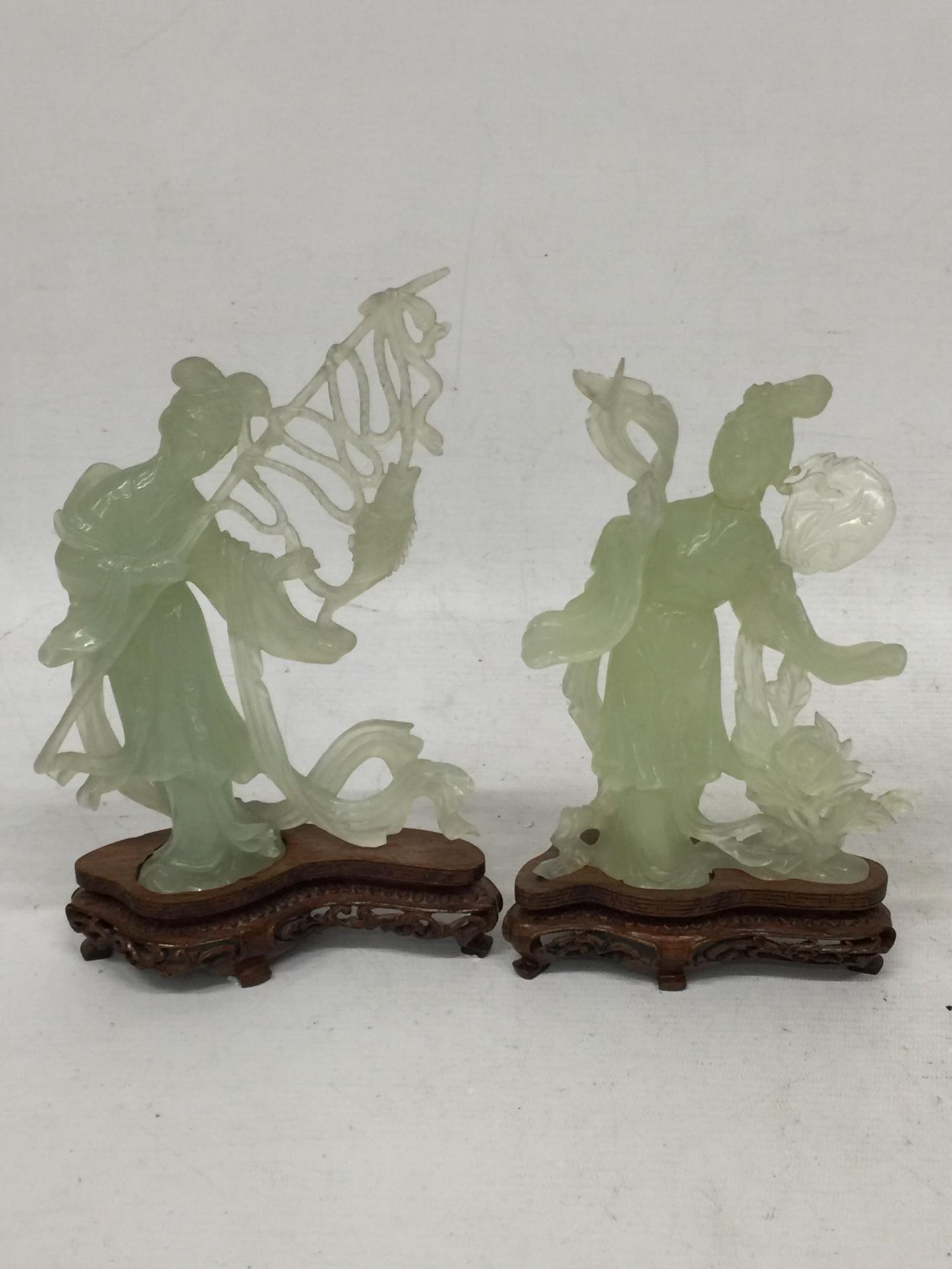 TWO CHINESE JADE TYPE CARVED FIGURES ON STANDS