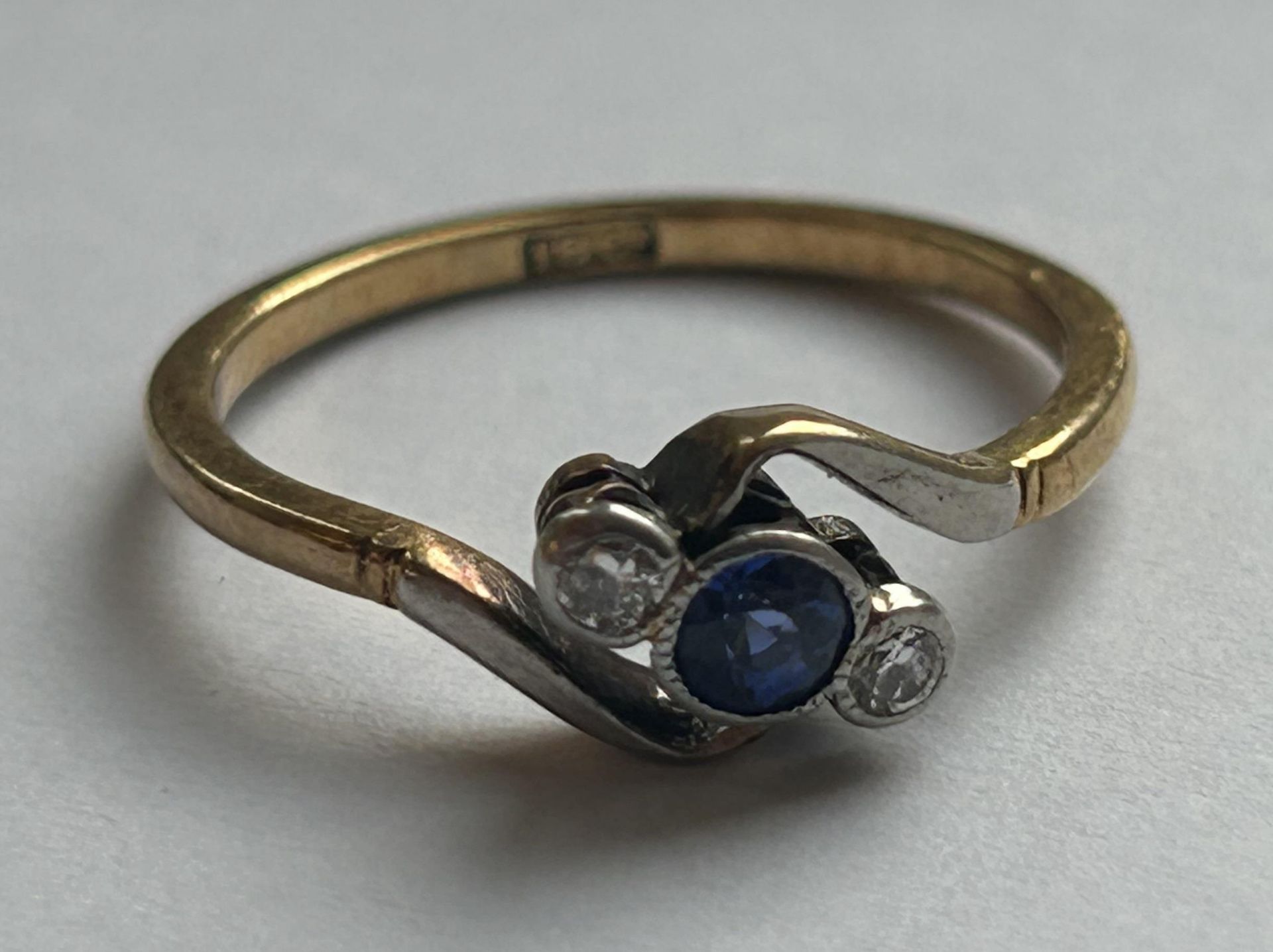 AN 18CT YELLOW GOLD AND PLATINUM, DIAMOND AND SAPPHIRE CROSSOVER RING SIZE L, WEIGHT 2.26 GRAMS