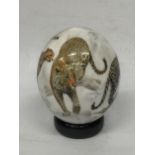 A HAND PAINTED OSTRICH EGG ON STAND WITH CHEETAH DESIGN, INDISTINCTLY SIGNED