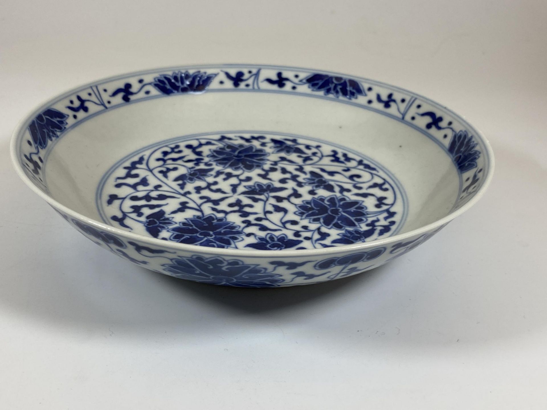 A CHINESE QIANLONG STYLE BLUE AND WHITE FLORAL BOWL / DISH, SIX CHARACTER MARK TO BASE, DIAMETER - Image 3 of 6