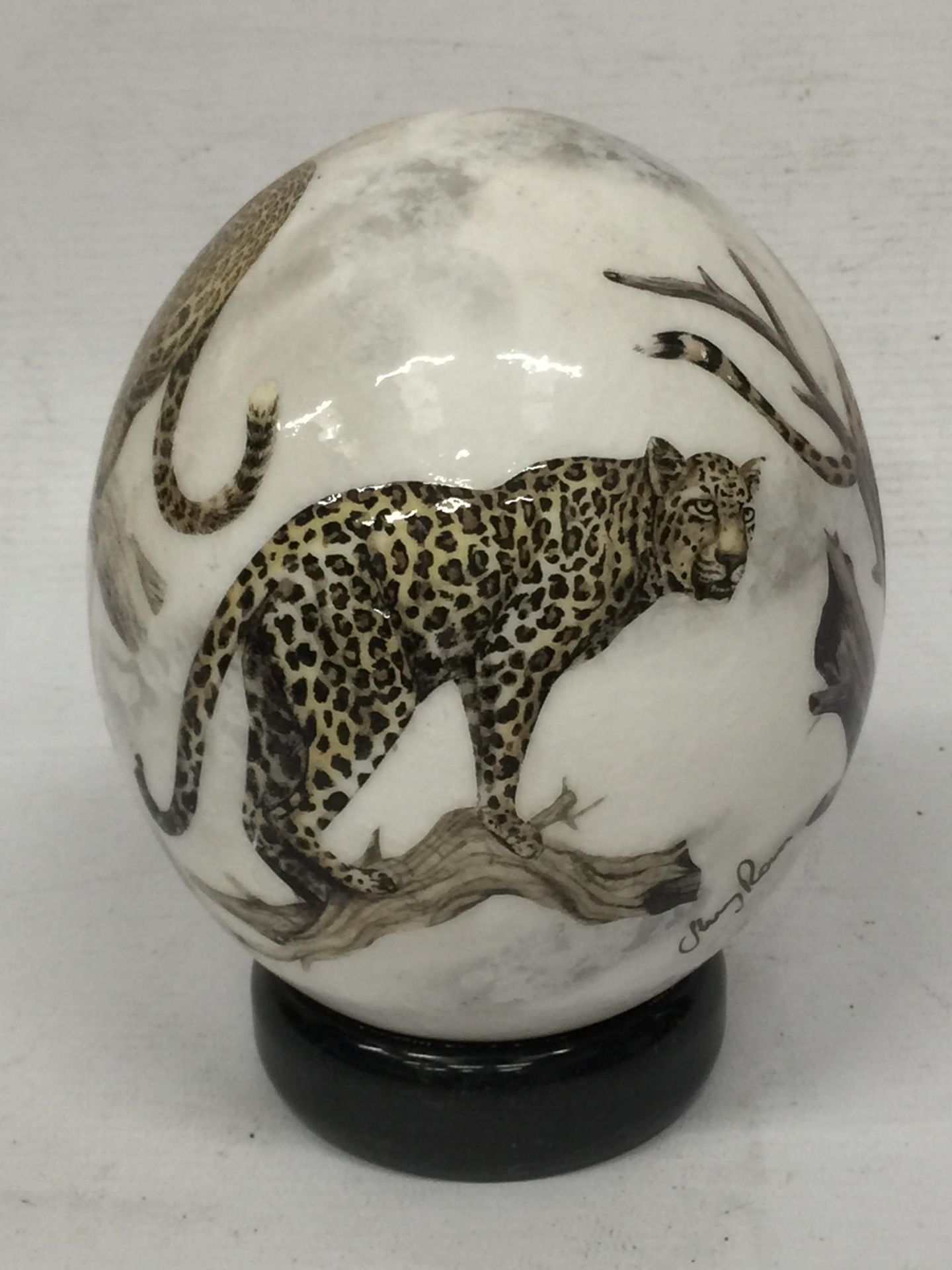 A HAND PAINTED OSTRICH EGG ON STAND WITH CHEETAH DESIGN, INDISTINCTLY SIGNED - Image 2 of 5