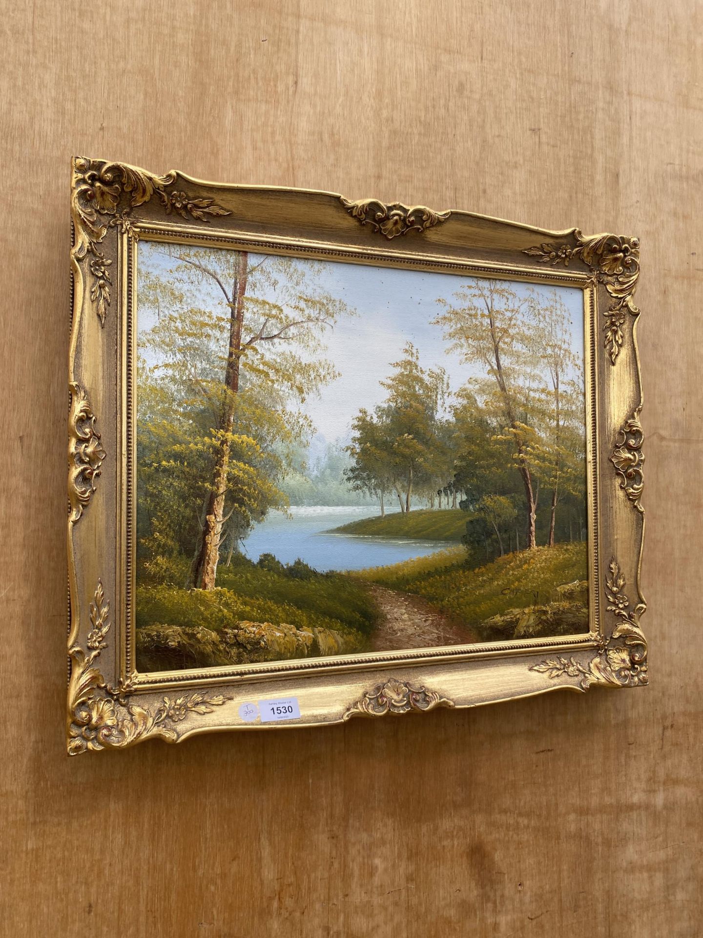 A GILT FRAMED OIL ON CANVAS OF A FOREST SCENE, INDISTINCTLY SIGNED