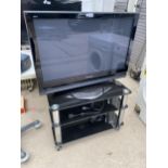 A PANASONIC TELEVISION WITH GLASS TV STAND, CABLE AND REMOTES