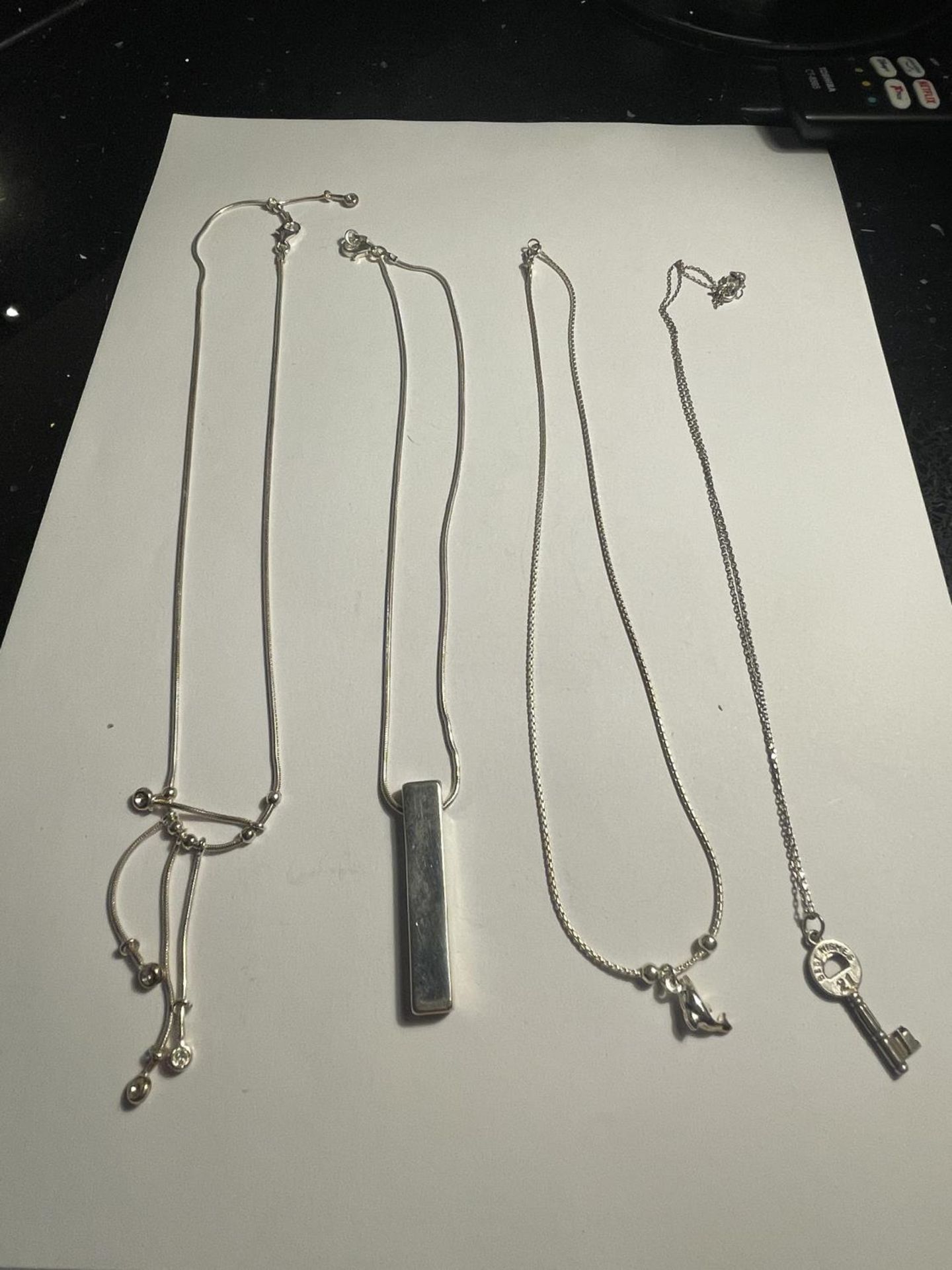 FOUR SILVER NECKLACES WITH PENDANTS