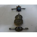 A SILVER WORLD WAR II A.R.P. BADGE AND TWO SILVER AND ENAMEL BROOCHES (3)