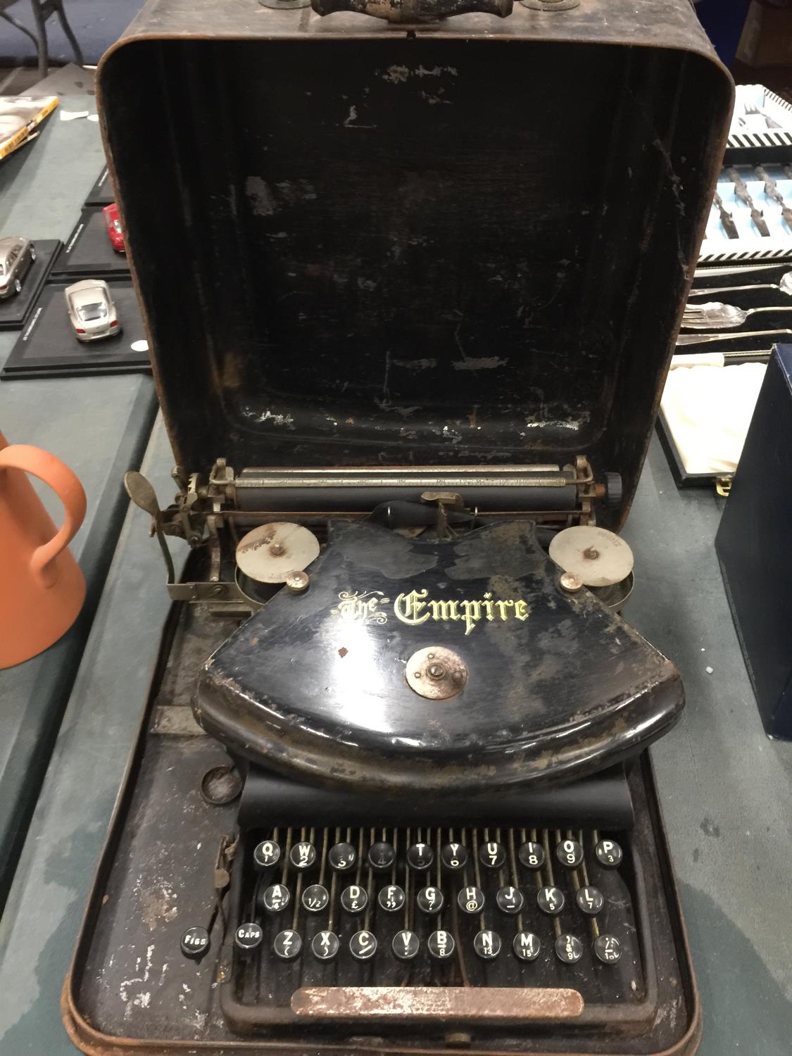 A VINTAGE 'THE EMPIRE' TYPEWRITER IN METAL CASE