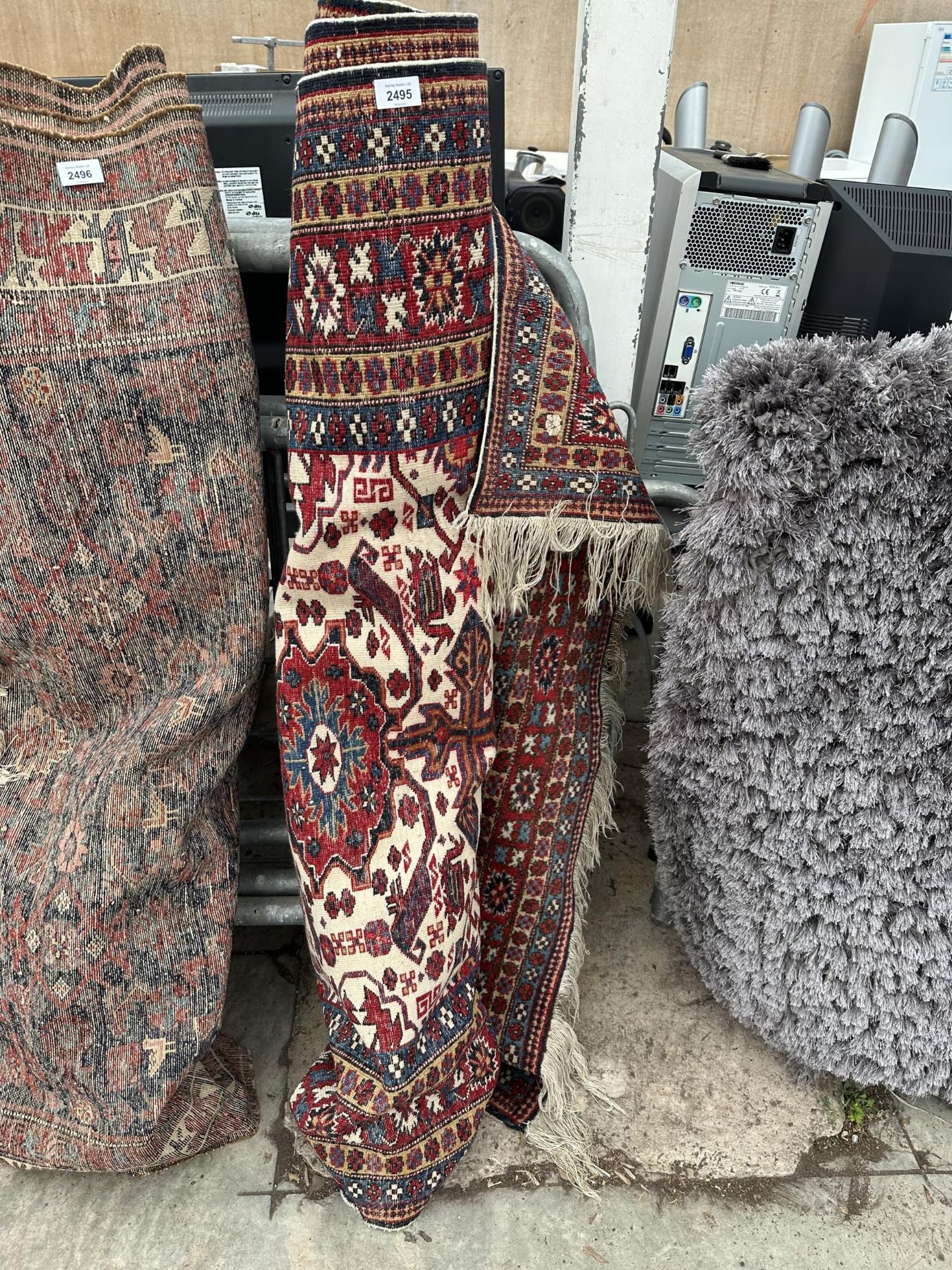 A VINTAGE RED PATTERNED FRINGED RUG