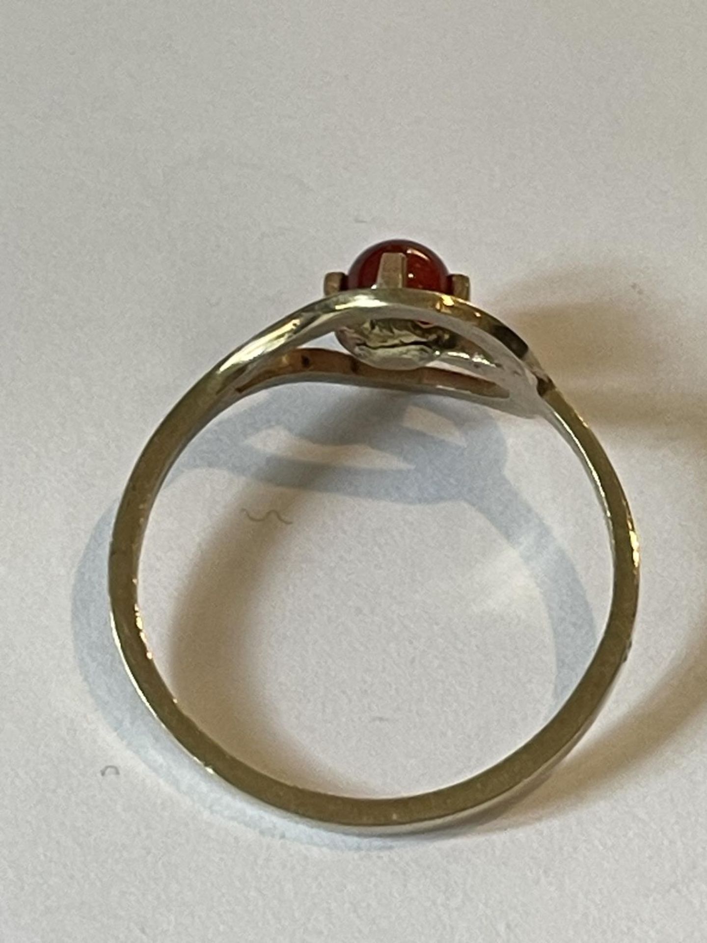 A 9 CARAT GOLD RING WITH A SPHERICAL GARNET IN A HEART SETTING SIZE O - Image 3 of 3