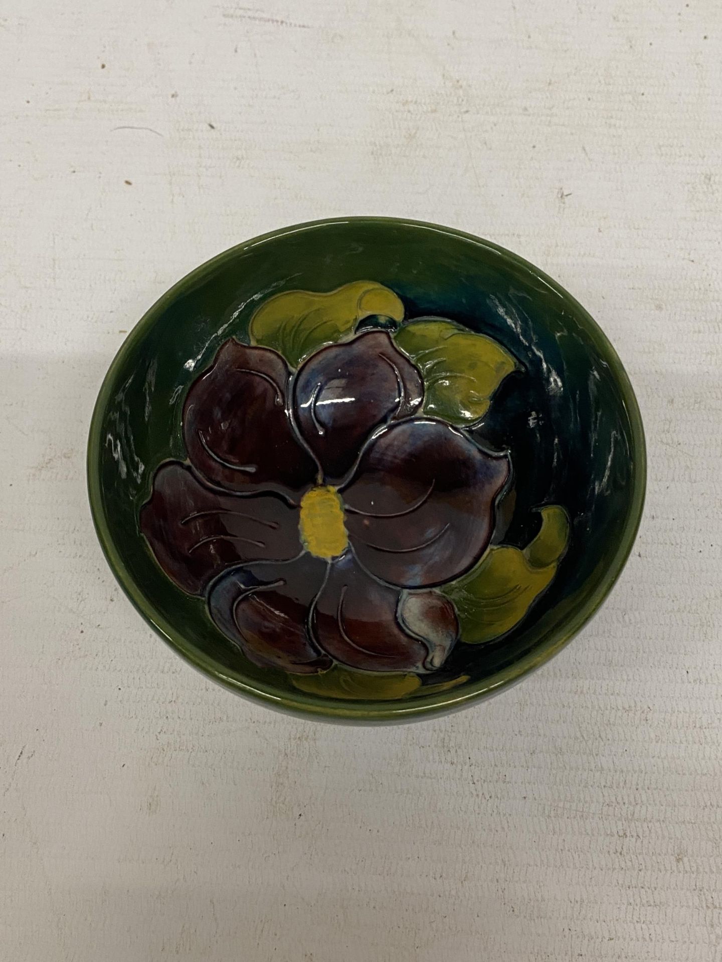 A MOORCROFT CLEMATIS BOWL ON GREEN GROUND