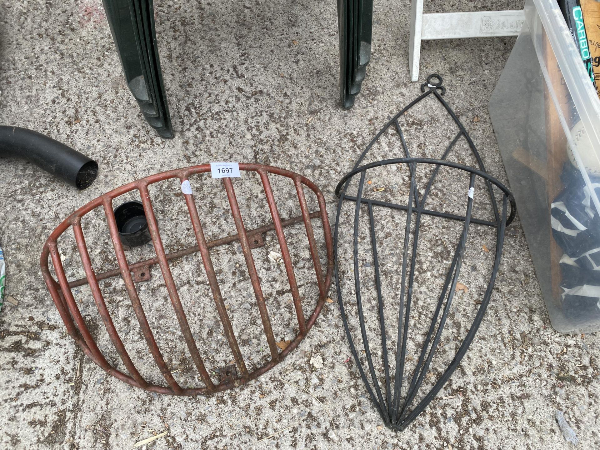 A SMALL METAL HAYRACK PLANTER AND A FURTHER DECORATIVE METAL WALL MOUNTED PLANTER