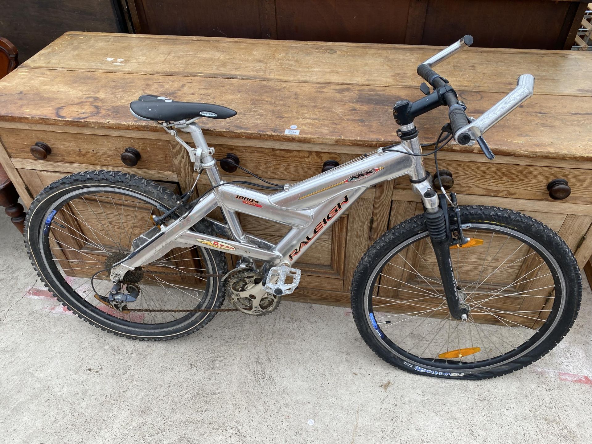 A BOYS RALEIGH MAX MOUNTAIN BIKE WITH FRONT SUSPENSION AND 27 SPEED GEAR SYSTEM