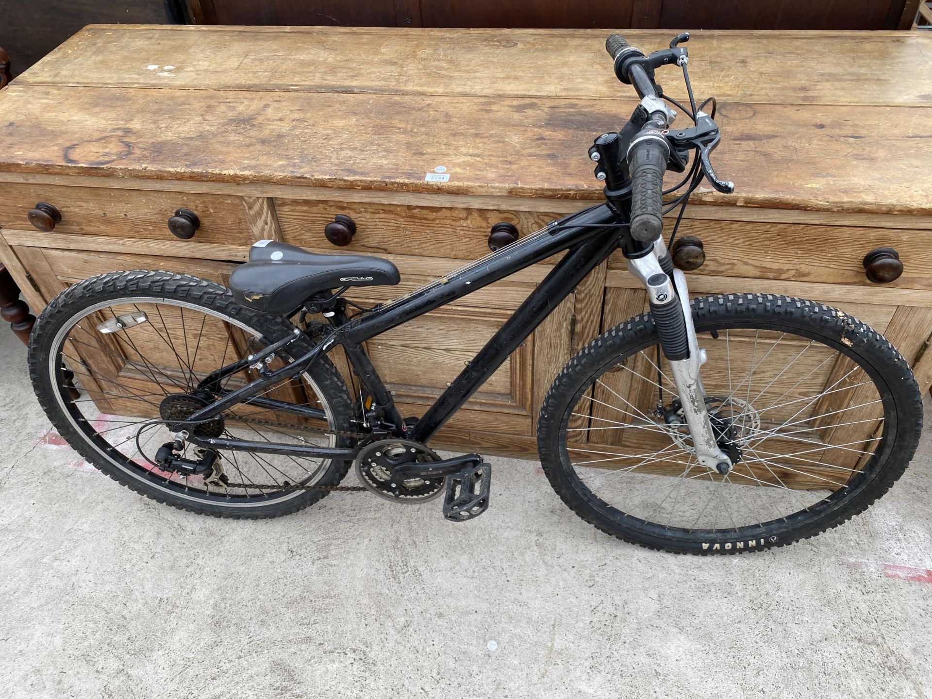 A BOYS MOUNTAIN BIKE WITH FRONT SUSPENSION AND 18 SPEED SHIMANO GEAR SYSTEM