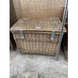 A LARGE WICKER LOG BASKET WITH HINGED LID AND METAL BANDING