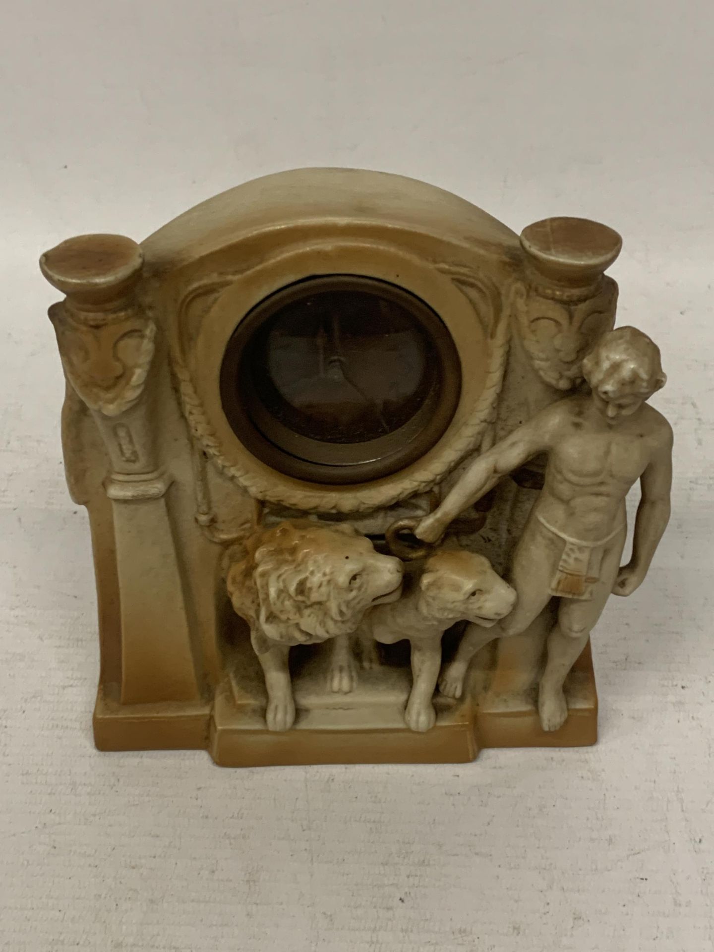 A CLASSICAL POTTERY MANTLE CLOCK WITH LION AND FIGURE DESIGN