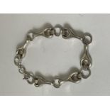 A SILVER BRACELET WITH SPANNER STYLE DESIGN