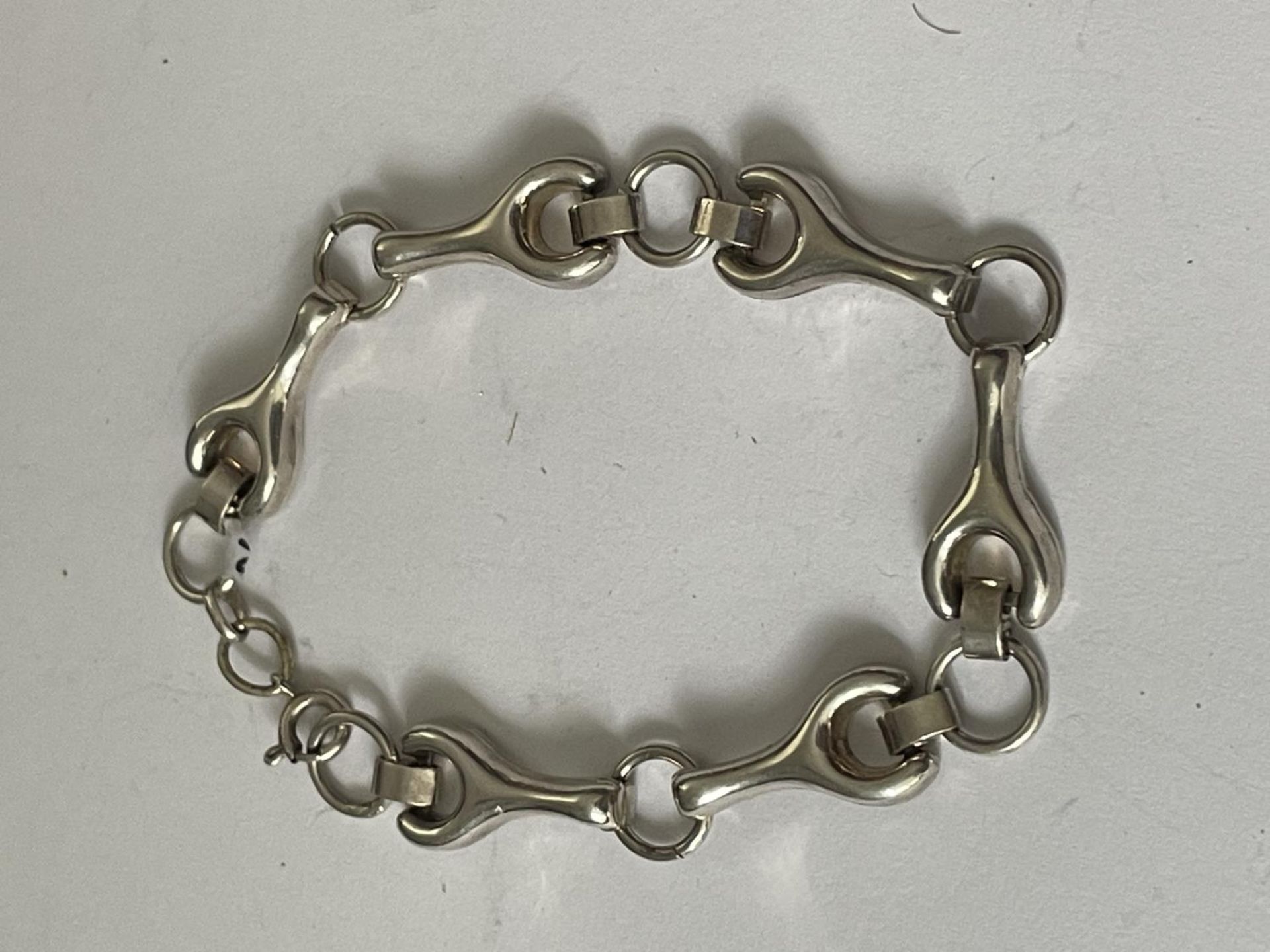 A SILVER BRACELET WITH SPANNER STYLE DESIGN