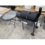 A CHARCOAL BBQ AND A GLASS TOPPED PATIO TABLE