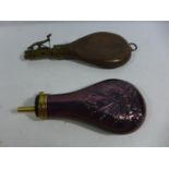 AN ANTIQUE LEATHER AND BRASS SHOT FLASK AND A COPPER AND BRASS POWDER FLASK (2)