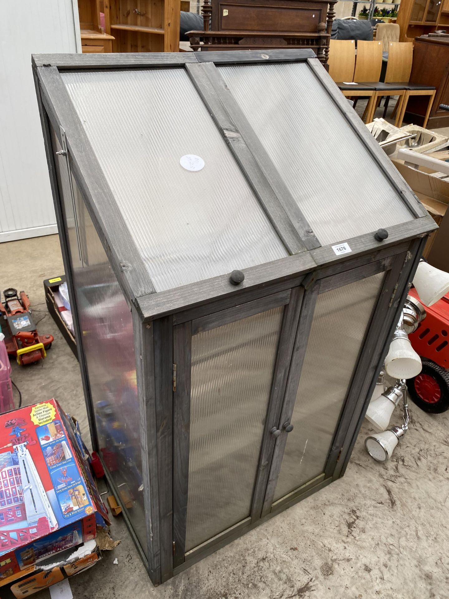 A WOODEN AND CORRUGATED PLASTIC GARDEN GROW SHED