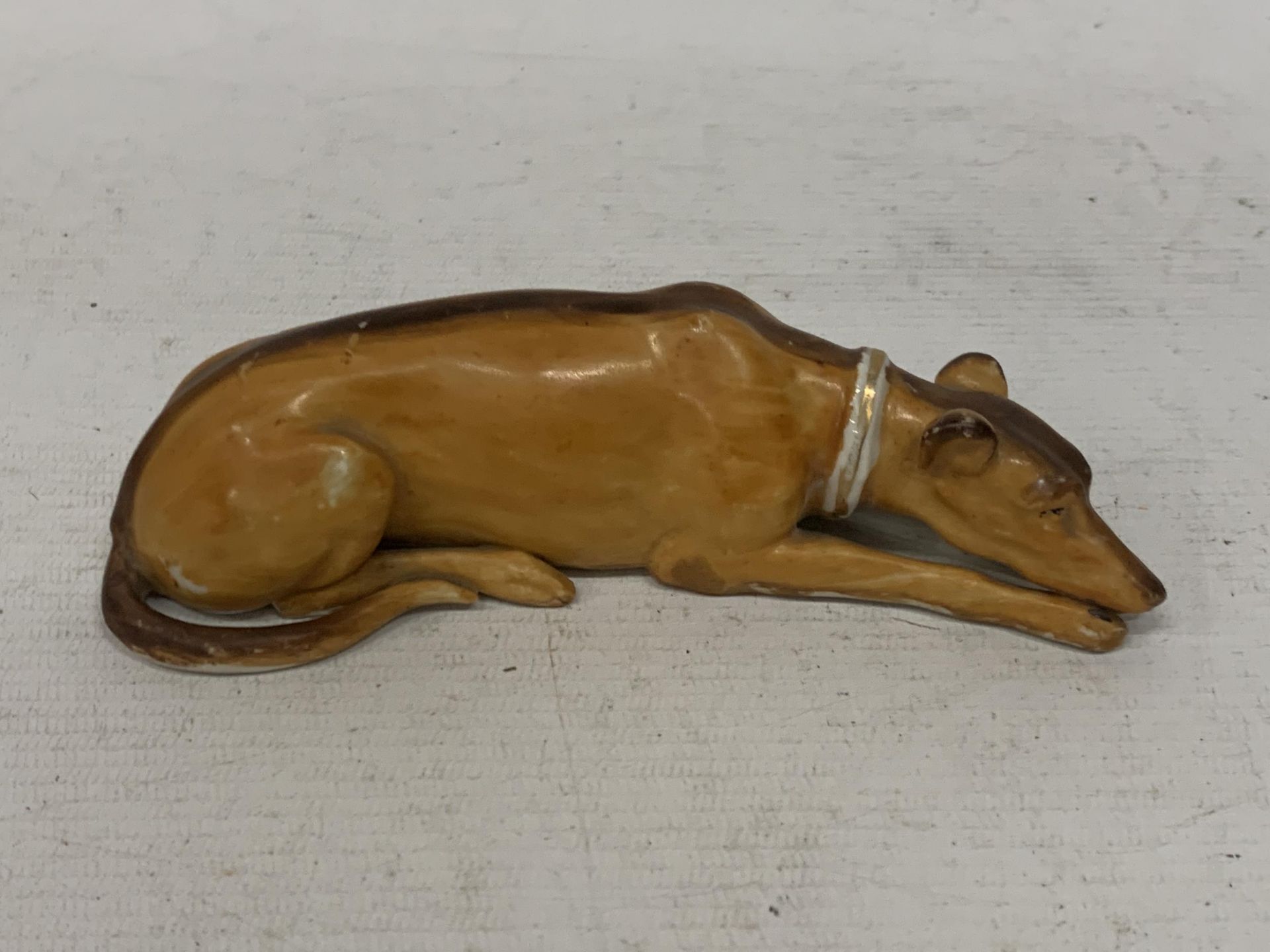 A POSSIBLY DOULTON UNMARKED LYING DOWN DOG ANIMAL FIGURE