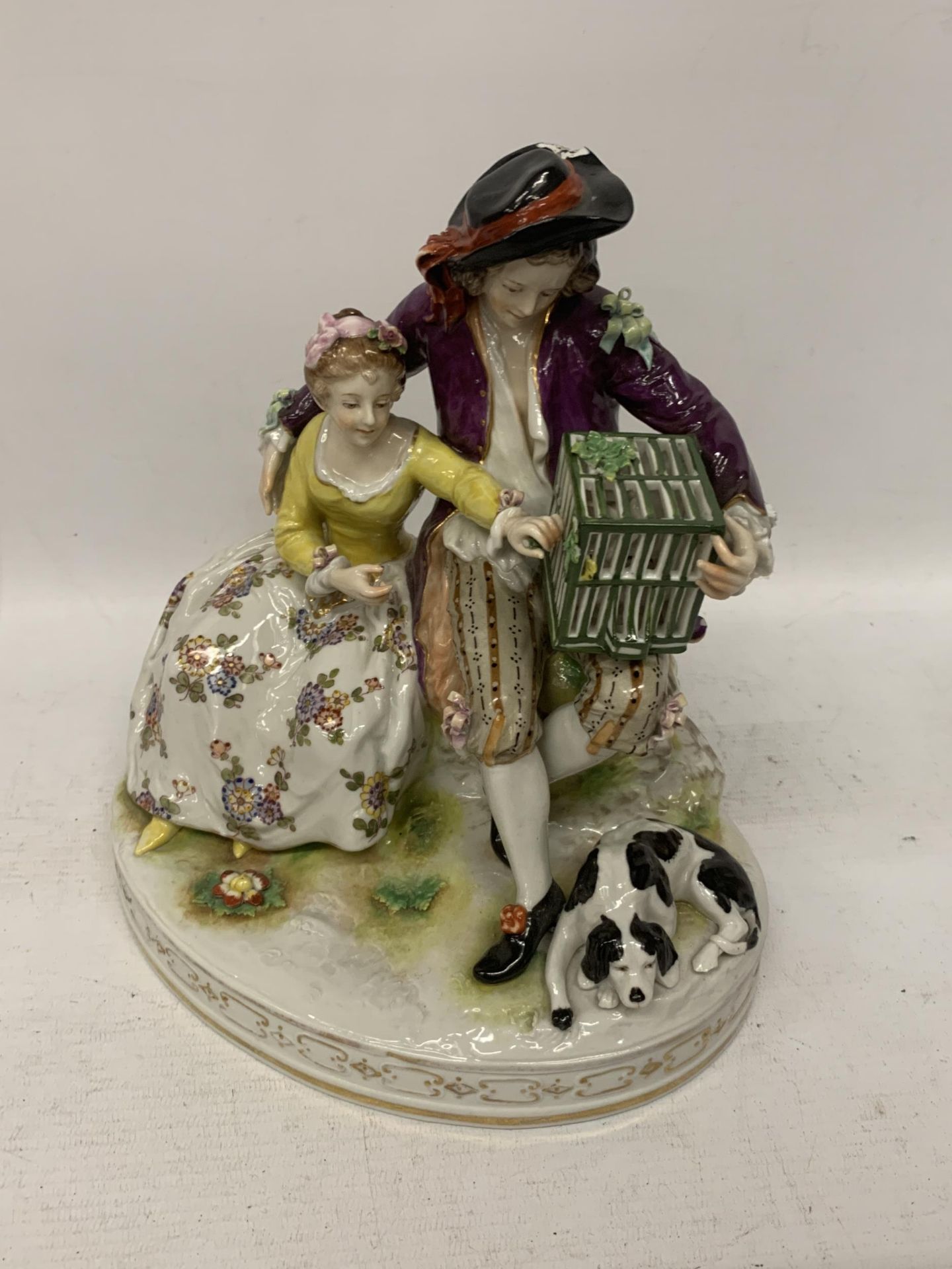 A BELIEVED RUDOLFSTADT CONTINENTAL PORCELAIN FIGURE GROUP DEPICTING A GENT AND LADY WITH A DOG