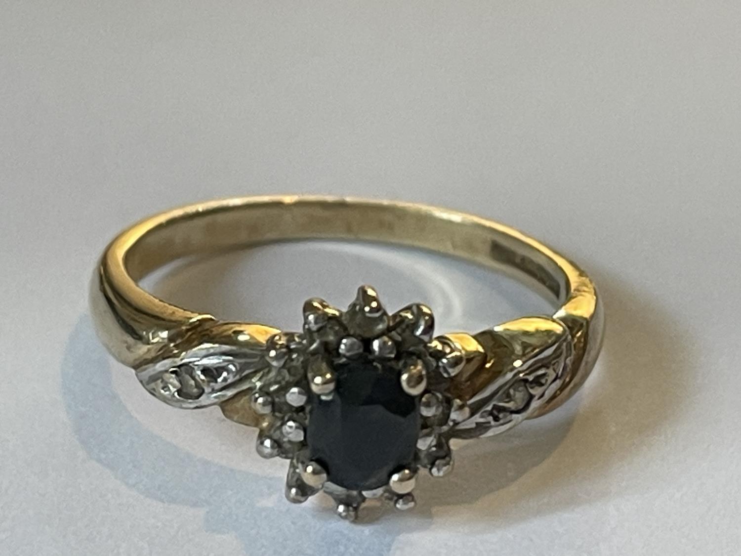 A 9 CARAT GOLD RING WITH A CENTRE SAPPHIRE SURROUNDED BY DIAMONDS SIZE O
